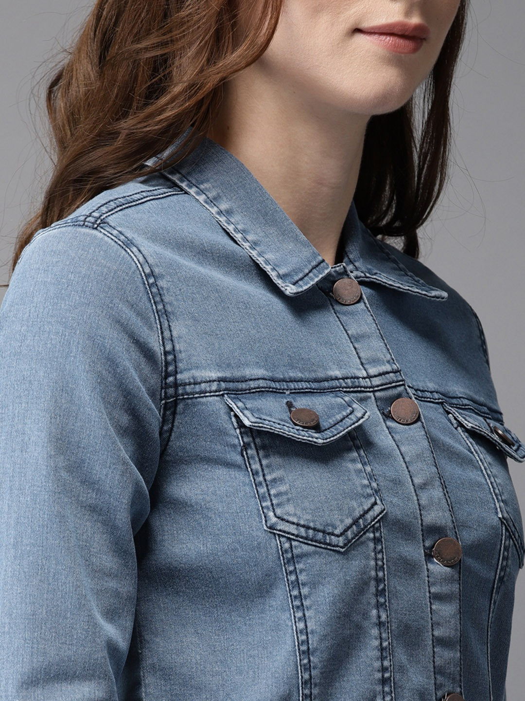 Denim jacket for women, featuring a cropped design and solid blue color, with buttons and pockets on the front.