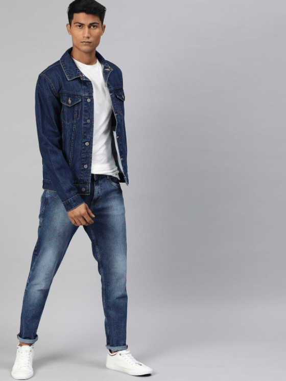 Dark blue denim jacket worn by young male model, paired with classic blue jeans and white sneakers.