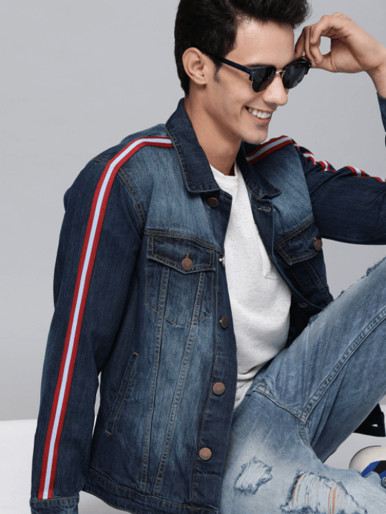 Dark blue denim jacket with red and white striped details, worn by a smiling man with black sunglasses