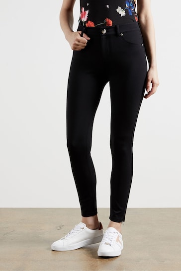 High-waisted black skinny jeggings with zip cuffs from Ace Cart's Ted Baker collection.