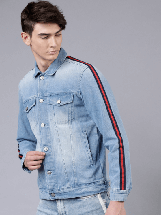 Light blue denim jacket with red striped details, worn by a young man against a gray background.