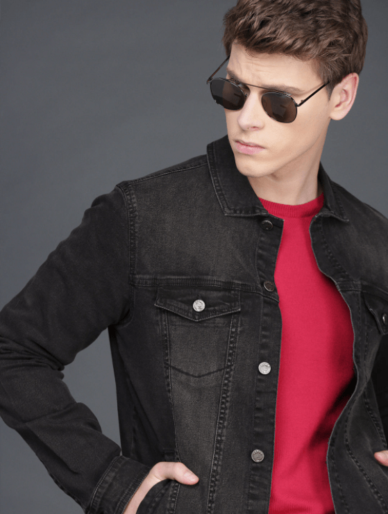 Stylish black denim jacket, classic aviator sunglasses, and bold red t-shirt on a male model.