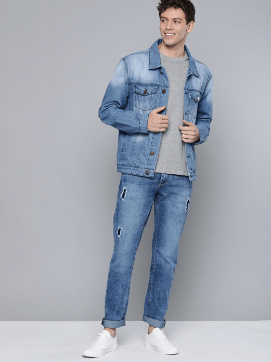 Light blue denim jacket with distressed design, worn by a young man with casual attire.