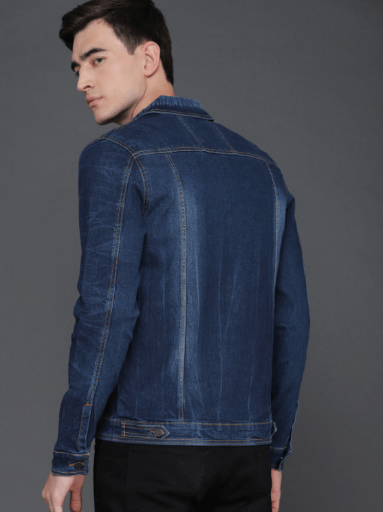 Dark blue denim jacket with classic collar and zipper closure, worn by a young male model against a gray background.