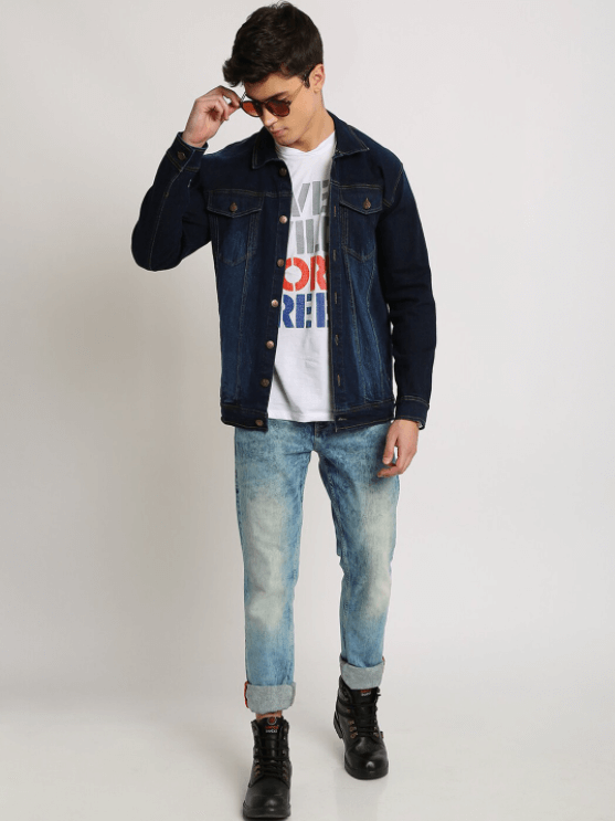 Dark blue denim jacket for stylish men, worn with graphic tee and relaxed fit jeans, paired with rugged boots for a casual, versatile look.