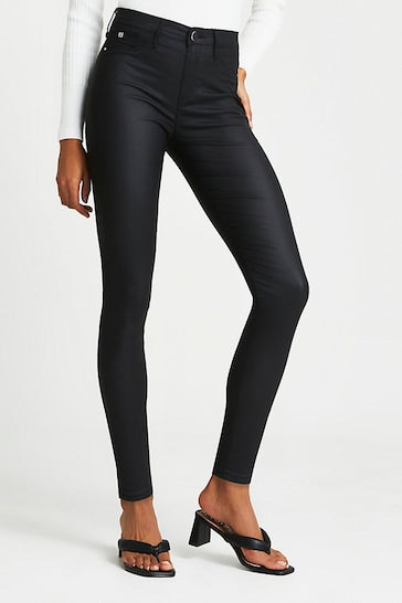 Sleek black coated skinny jeans from Ace Cart's Joyride Molly collection, featuring a high-waisted stretch fit and molded knees for a stylish, flattering look.