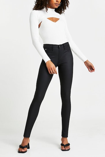 Stylish white bodysuit with cutout detail and sleek black skinny jeans from the Ace Cart fashion brand.