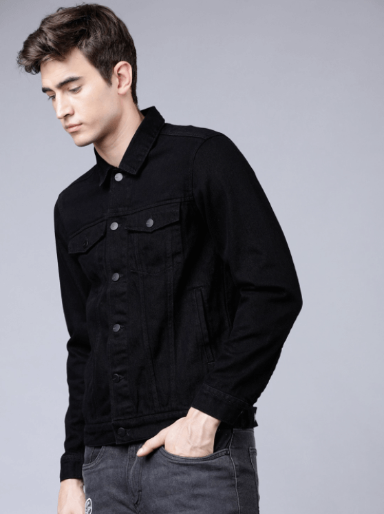 Black denim jacket worn by a young man with short dark hair against a plain background.
