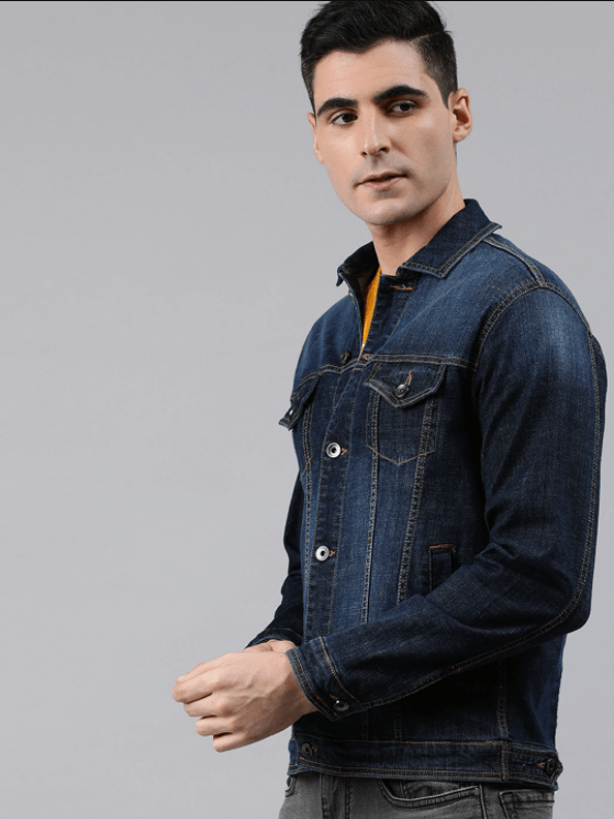 Man wearing dark blue denim jacket with front pockets and buttons.