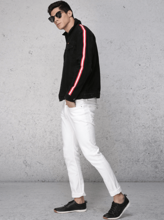 Black denim jacket with bold red stripes, slim white jeans, and black sneakers worn by a stylish male model against a plain white background.