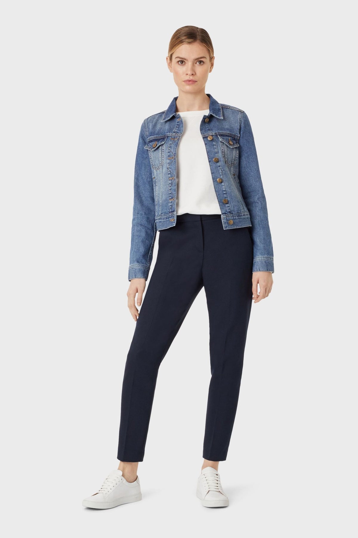 Classic blue denim jacket from Ace Cart's collection, worn with white top and black pants. Versatile and stylish outfit perfect for everyday wear.