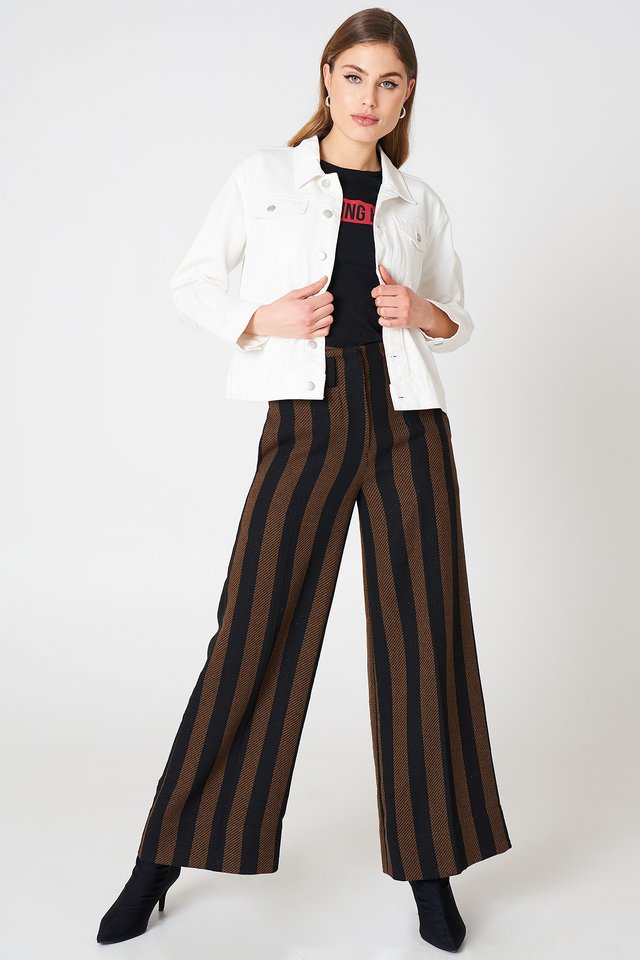 Woman in white denim jacket with striped wide-leg pants