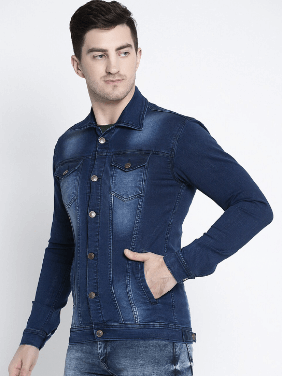 Dark blue denim jacket with button closure and pockets worn by a young man against a plain background.