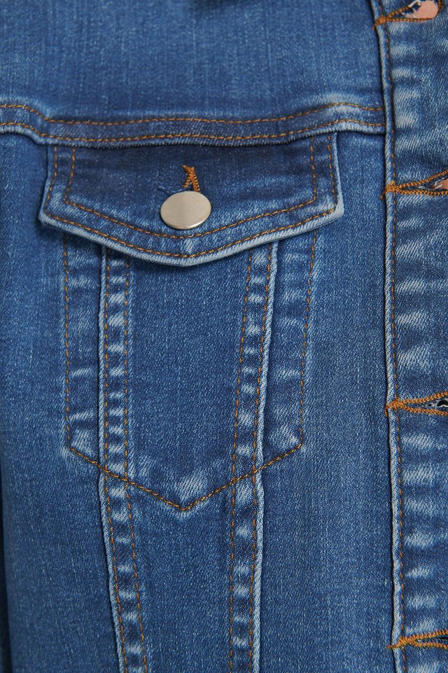 Blue denim jacket with functional pockets and metal snap buttons for a modern, casual style.