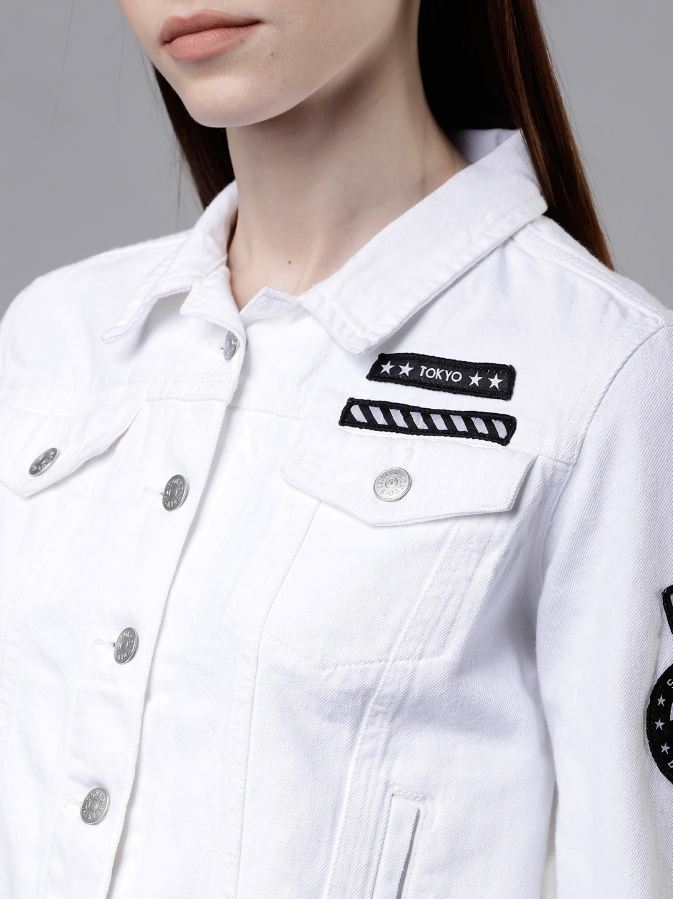 White Denim Jacket with Patches
This image shows a white denim jacket with embroidered patches featuring stars, stripes, and the word "TOKYO" on the chest pocket. The jacket is being worn by a young woman with long dark hair.