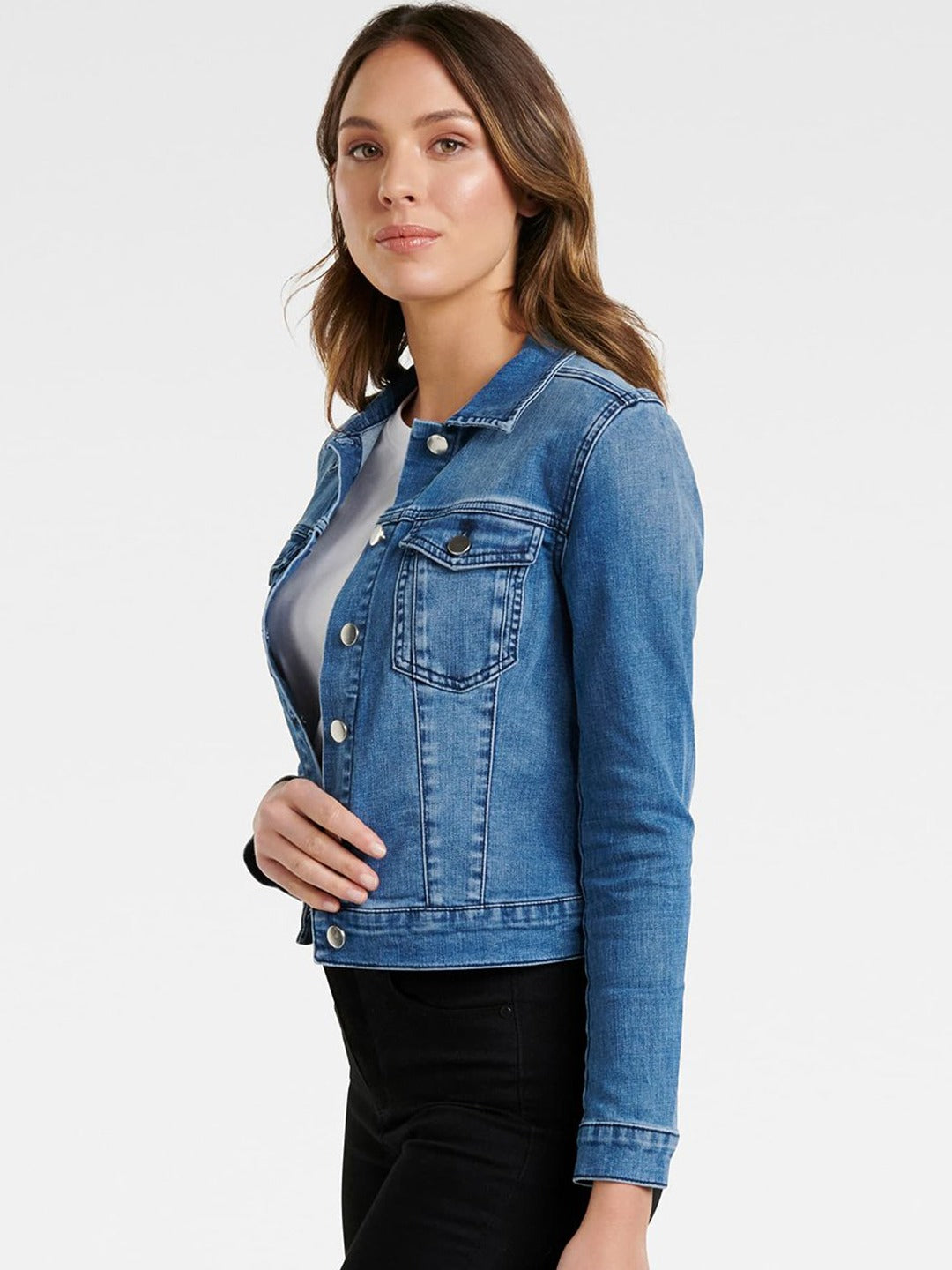 Blue denim jacket with button closures, worn by a young woman with brunette hair against a plain background.
