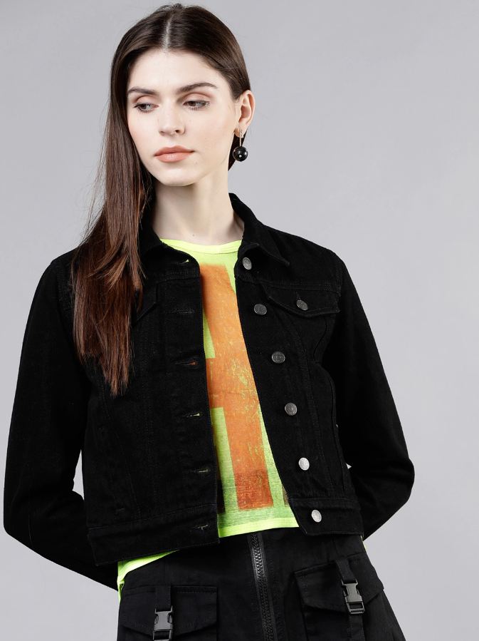 Stylish women's black denim jacket against plain background