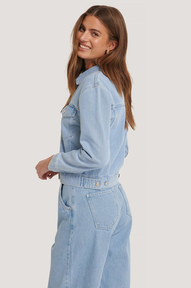 Light blue women's denim jacket with front pockets and belt loops.
