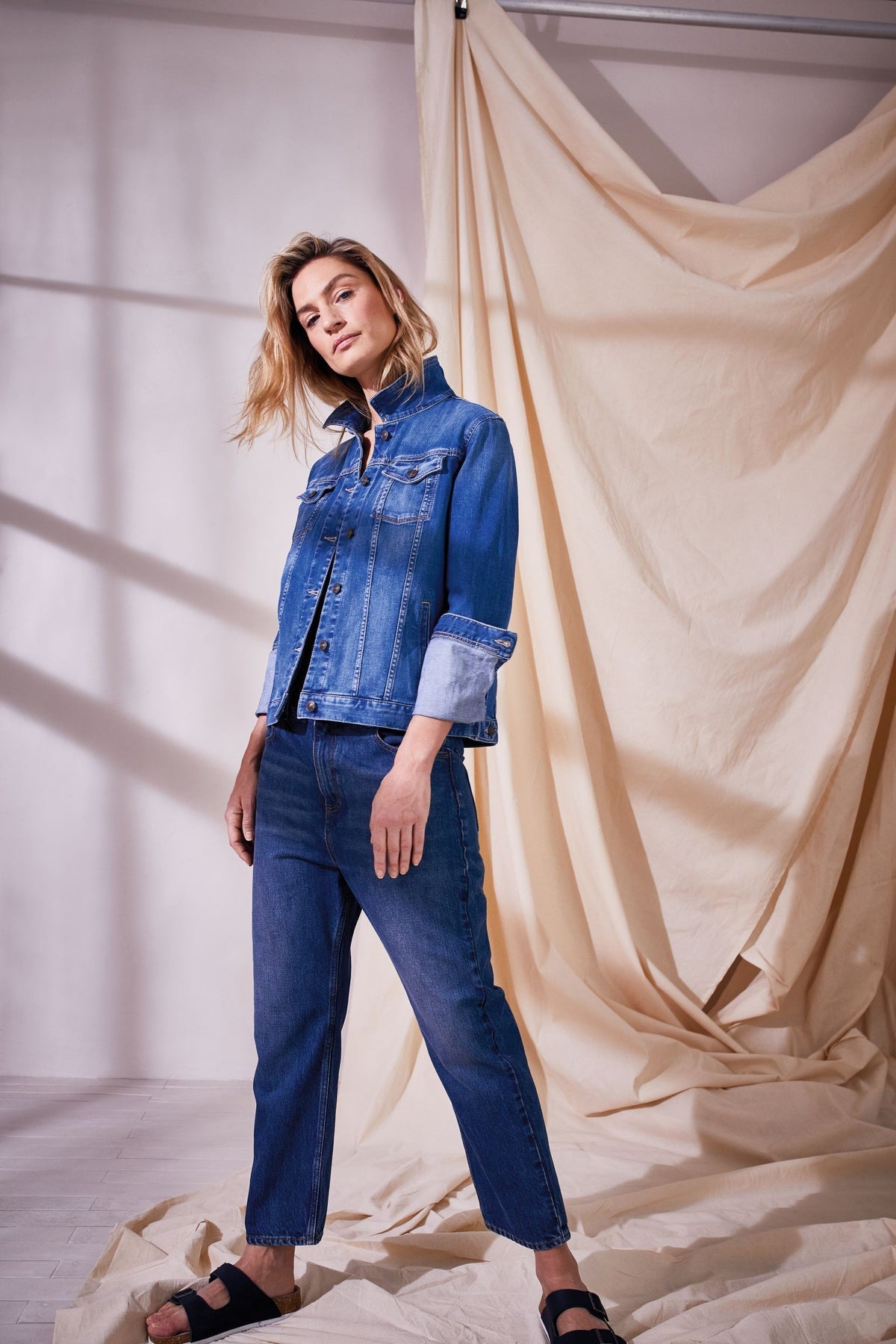 Stylish blue denim jacket and jeans on female model in studio