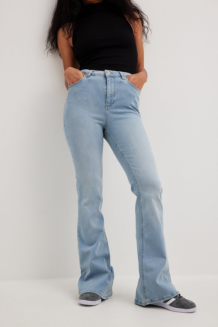 Flared high-waist stretch denim jeans with relaxed fit, displayed on a female model against a white background.