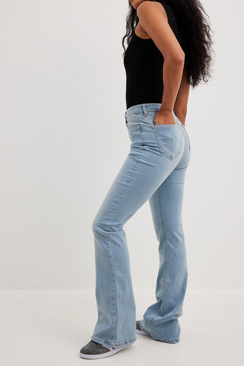 Flared high waist stretch denim jeans with a relaxed fit, showcased on a female model in a white background.