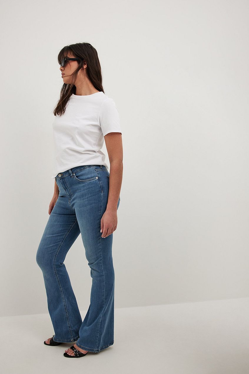 High-waisted flared denim jeans with a relaxed fit, worn by a person against a plain background