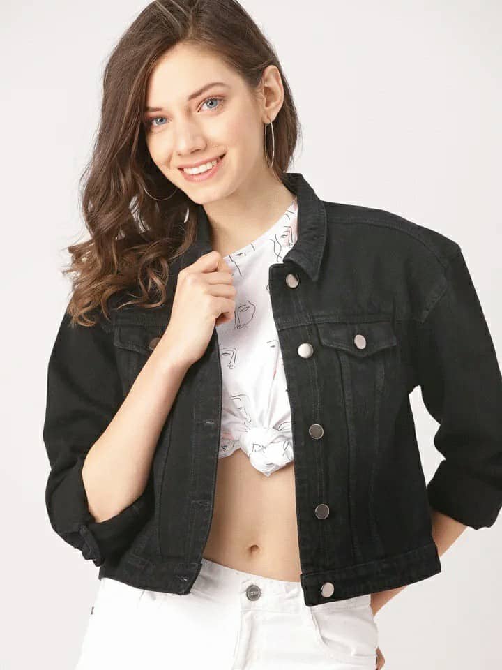 Black women's denim jacket with silver buttons, worn by smiling young woman with curly brown hair.