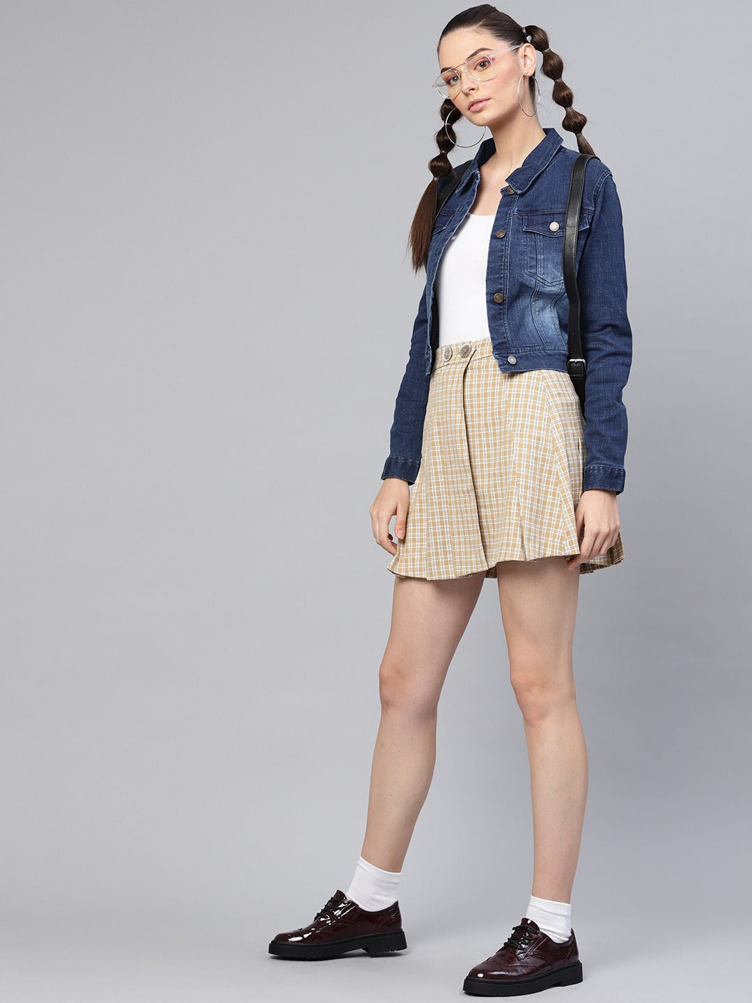 Stylish women's denim jacket with pleated skirt and platform shoes, showcasing a trendy casual outfit.