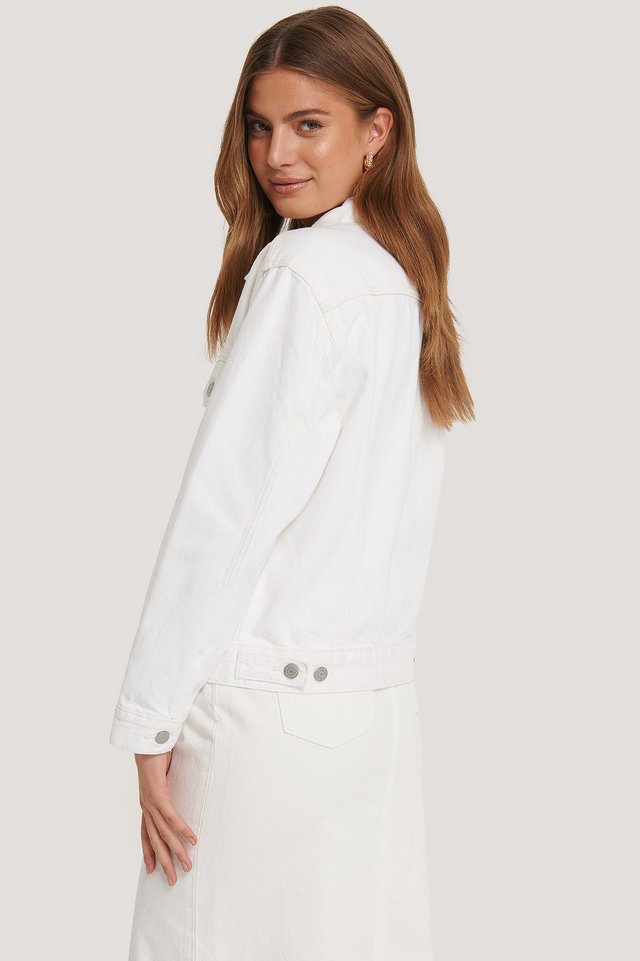 A white women's jacket on a model with long brown hair posing in a studio setting.