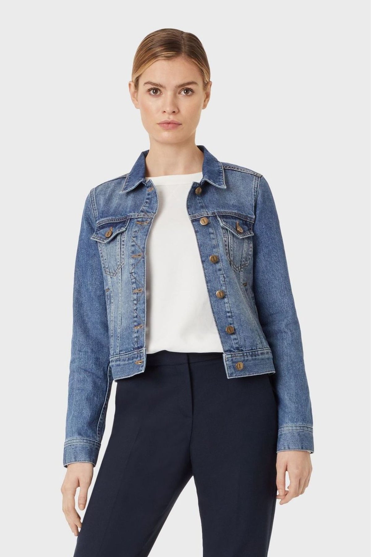 Denim jacket with collared neckline, blue wash, and brass button detailing on Hobbs product model