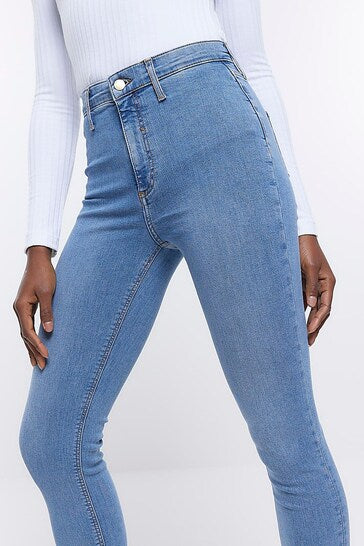High-rise light blue denim jeggings with ripped knee detail, showcasing a stretchy, curve-enhancing fit for women.