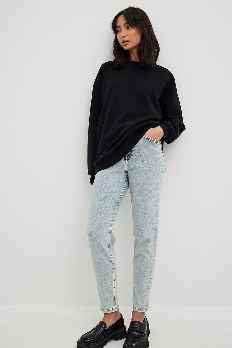 Relaxed fit organic mom jeans, stylish black sweater, casual woman's fashion, modern urban style.