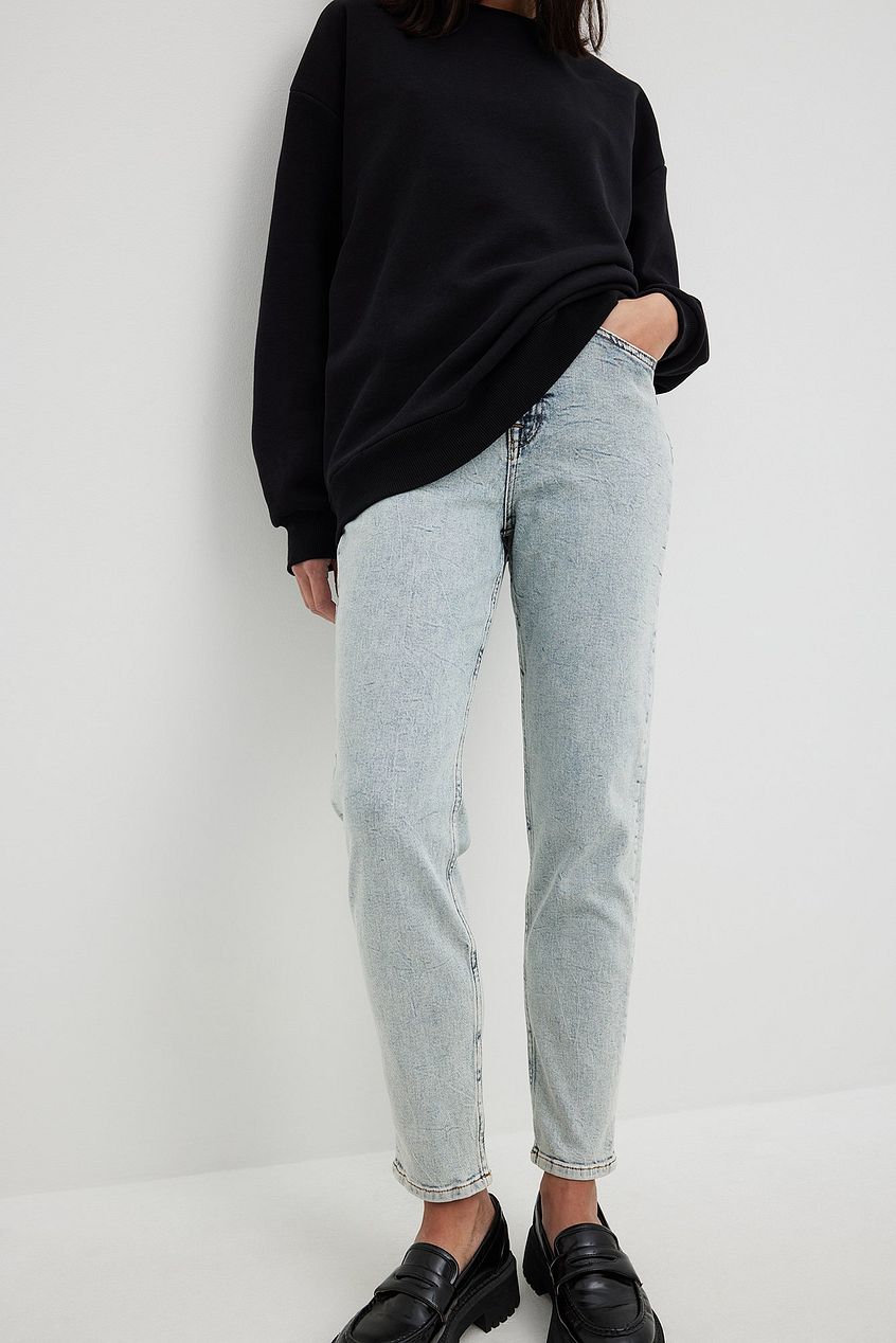 High-waist mom jeans, black oversized sweater, black loafers on a white background