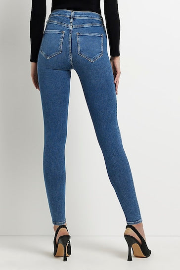 High-waisted blue denim jeggings with ripped knees from Ace Cart brand, worn with black heels.