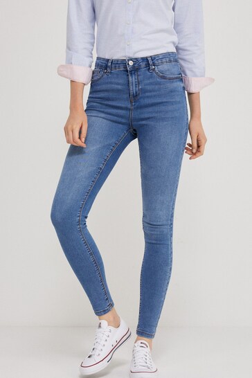 Blue wash high-waisted stretch jeggings worn with casual sneakers