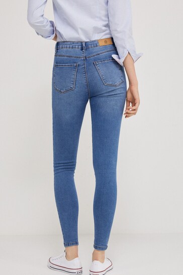 Stylish blue wash jeggings with ripped knees, showcasing a modern and trendy design for the fashion-forward woman.