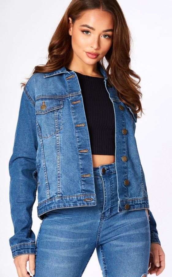 Blue denim jacket for women, cropped fit with button closure, worn over black top, showcased against plain background.