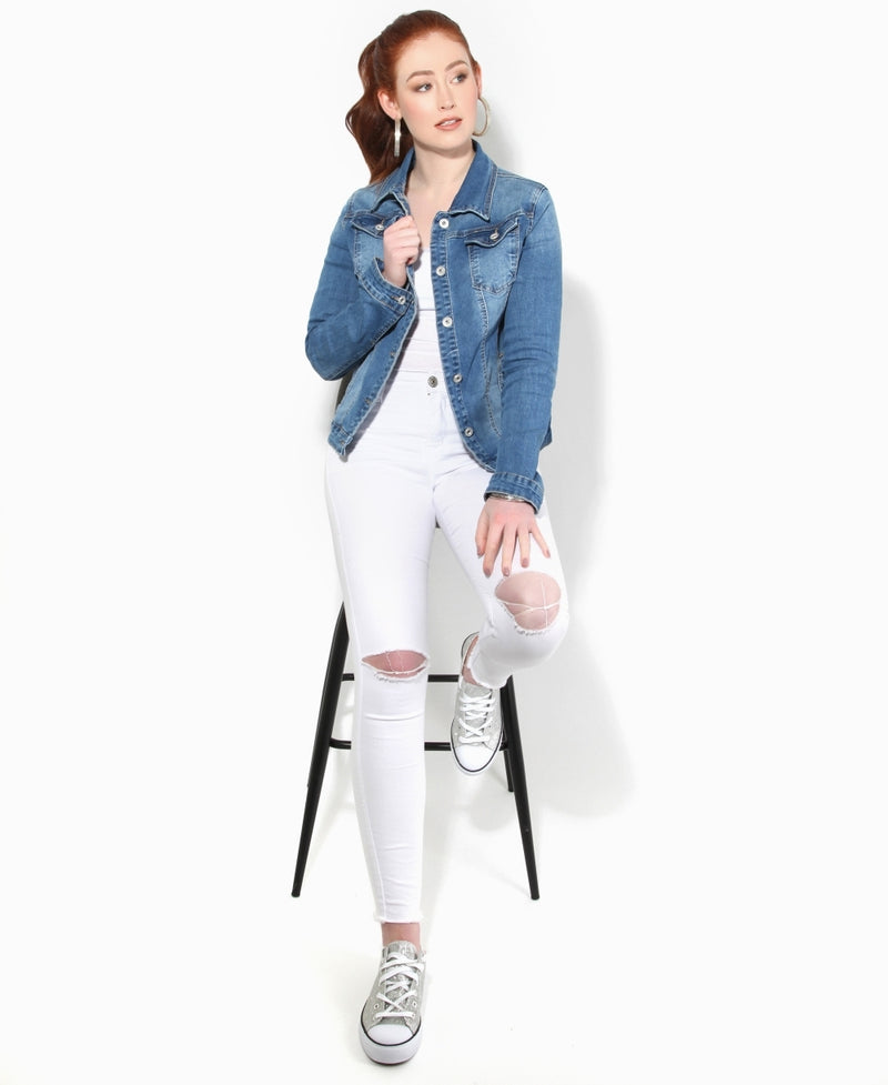 Stylish blue denim jacket for women, paired with white ripped jeans and casual sneakers, showcasing a trendy and fashion-forward look.