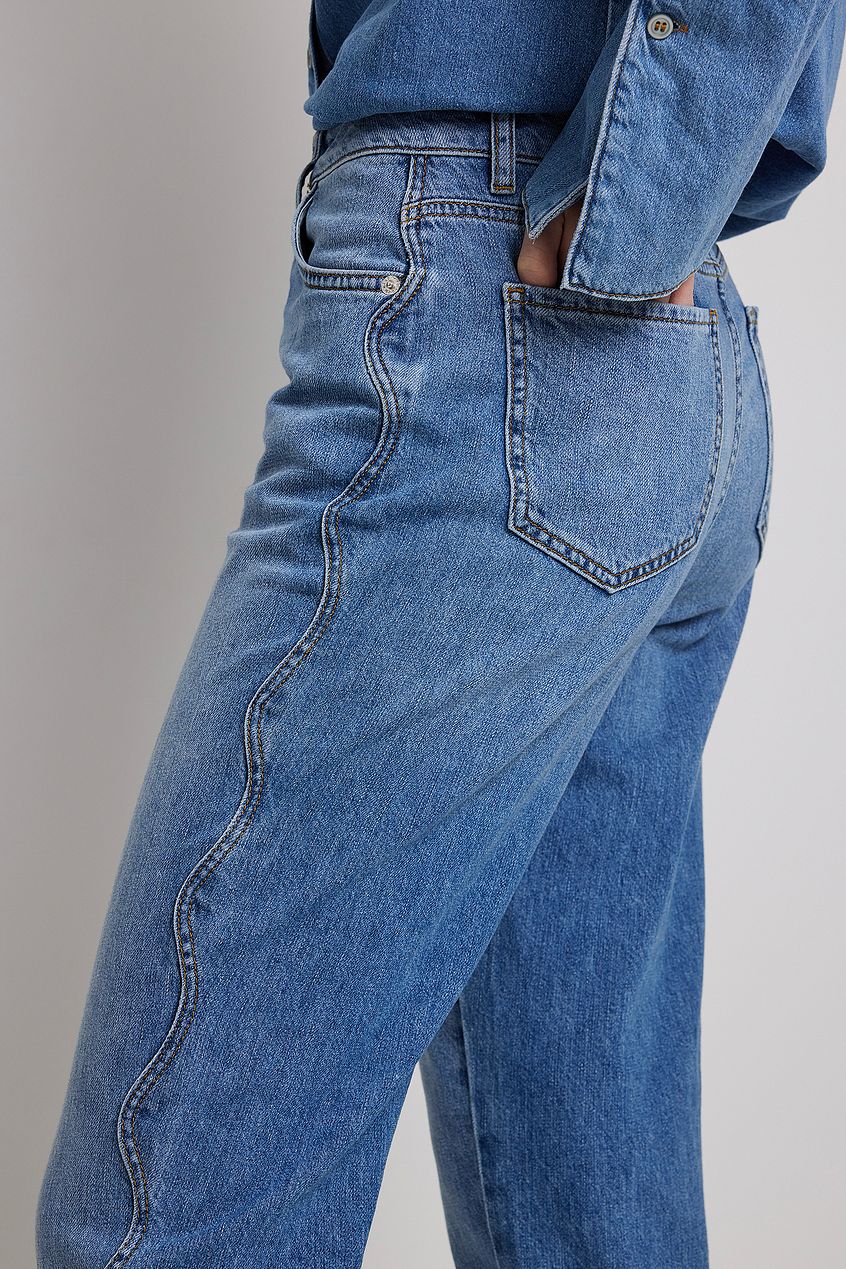 Detailed Denim: High-waist straight leg jeans with classic five-pocket design and faded blue wash, showcasing the quality craftsmanship of the Ace Cart denim collection.