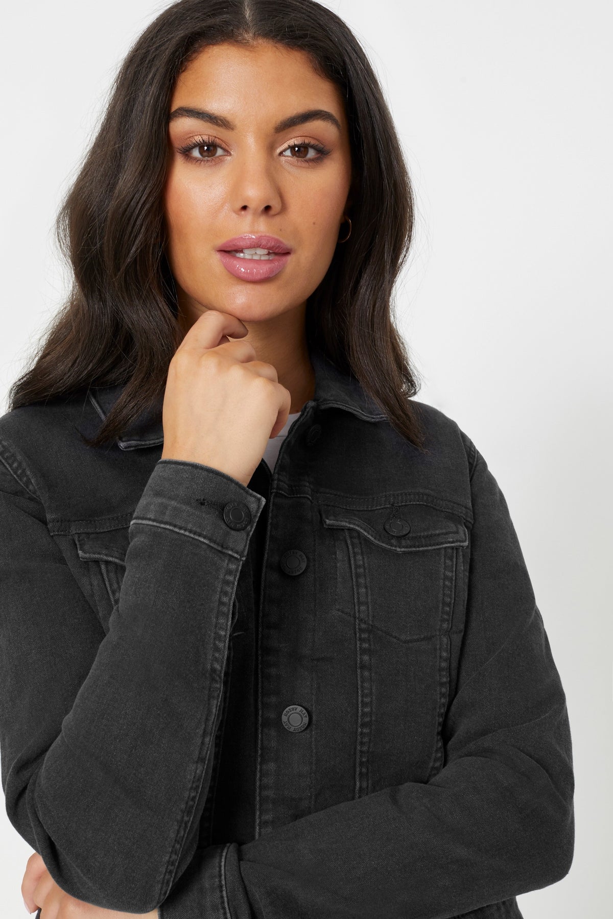 Stylish denim jacket for women, showcased on a thoughtful model.