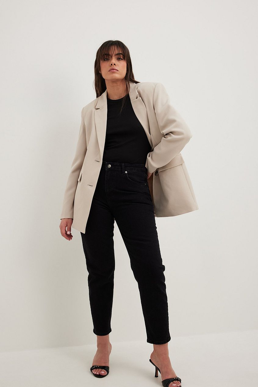 Stylish woman wearing beige blazer and black pants