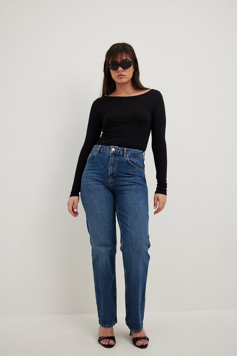 Black long-sleeved top, high-waisted blue jeans, and black sunglasses worn by a woman in the product image