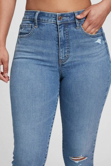 High-waisted rip knee universal jeggings in light blue denim with pockets, worn by a person.