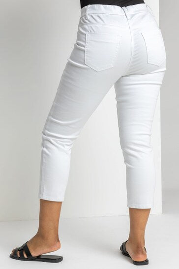 White cropped jeggings with high waist and ripped knees, designed for modern women's fashion.