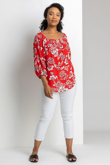 Stylish floral print blouse with puff sleeves and figure-flattering curvy model wearing white cropped jeggings from the Ace Cart collection.