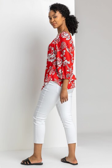 Vibrant red floral blouse, white cropped jeggings, casual yet stylish woman's outfit from Ace Cart store.