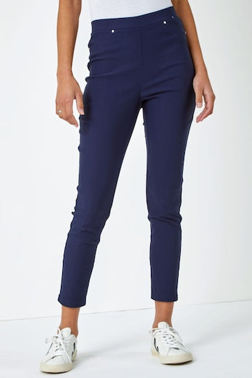 High-waisted navy blue stretch jeggings with a slim, skinny fit worn by a young woman in the image.