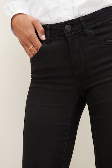 Sculpting stretch skinny black jeans with stylish ripped knee detail, perfect for a modern, edgy look.