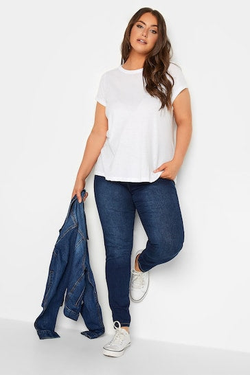 Soft white cotton t-shirt, stretchy dark blue jeggings, casual white sneakers - a comfortable, stylish outfit perfect for everyday wear.