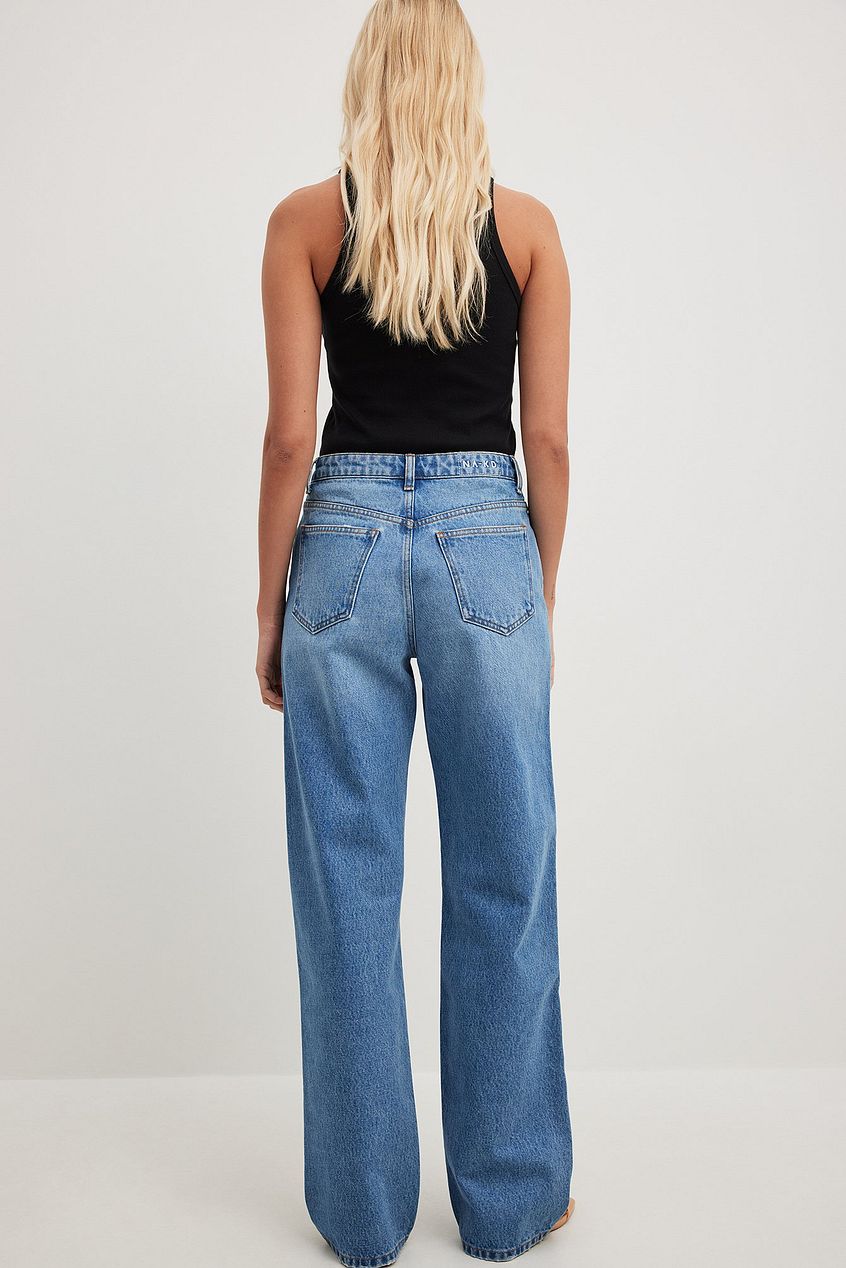 Loose mid-waist denim jeans on female model, wavy blonde hair